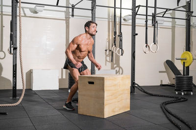 Shirtless man exercising at gym