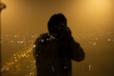 Man photographing illuminated cityscape at night