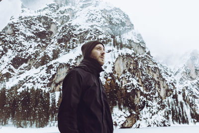 Man standing on snow covered tree