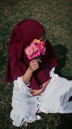 High angle view of woman sitting on grassy field