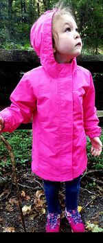 Cute girl standing with pink umbrella