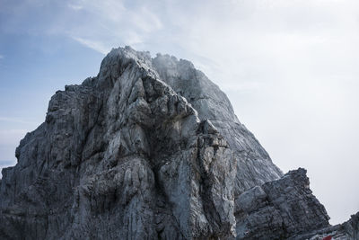 Low angle view of rocky mountain against sky