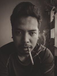 Portrait of young man smoking cigarette