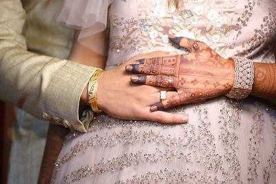 Midsection of couple holding hands