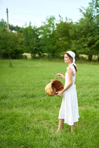 Full length of woman wearing hat standing on field