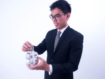 Portrait of a man holding camera over white background