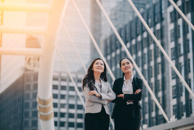 Businesswomen standing against modern office