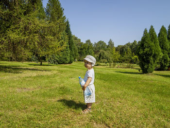 Sunny summer day little boy walking alone in the nature park field