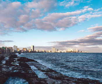 Scenic view of sea by buildings against sky