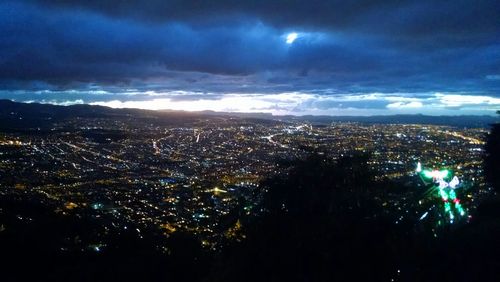 Aerial view of illuminated cityscape against sky at night