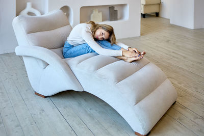 High angle view of woman lying on sofa at home