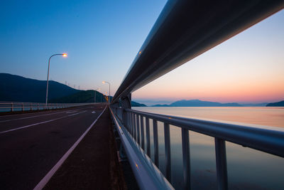 Bridge over road against sky during sunset