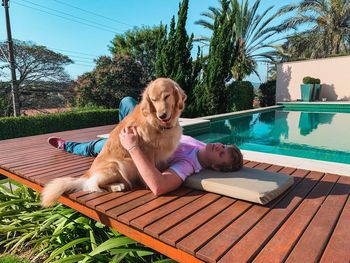 Woman with dog by swimming pool