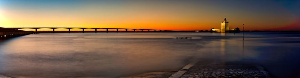 Bridge over river against sky during sunset