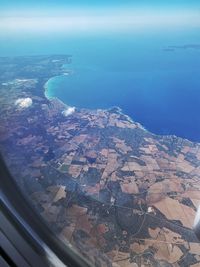 Aerial view of sea seen through airplane window