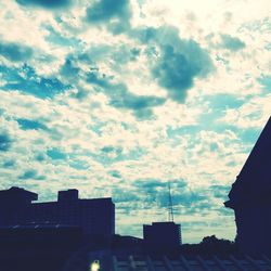 Low angle view of buildings against cloudy sky