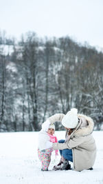 Girl in snow against trees during winter