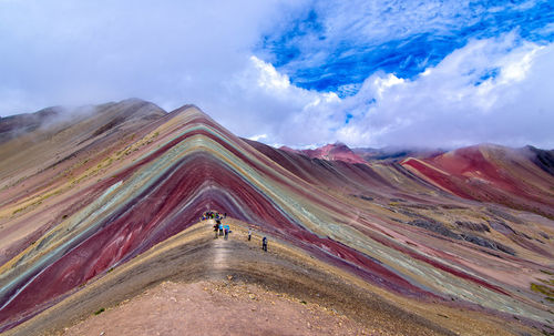 Rear view of people on mountain against sky
