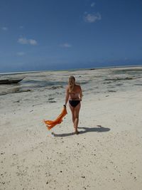 Full length of woman on beach against sky