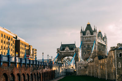 Arch bridge over river against buildings in city