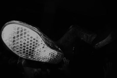 Low section of man wearing shoes standing against black background