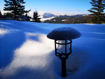 Snow on field against blue sky