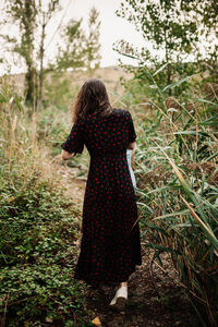 Rear view of woman walking in forest