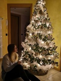 Woman looking at christmas tree at home