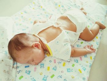 High angle view of newborn baby sleeping on bed at home
