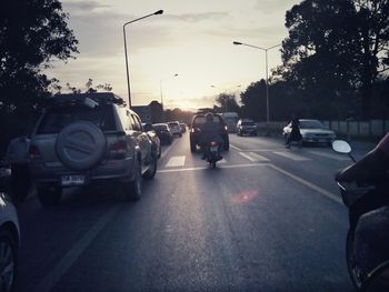 Traffic on road at sunset