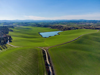 High angle view of road amidst field against sky