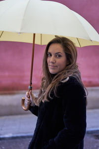 Portrait of young woman holding umbrella