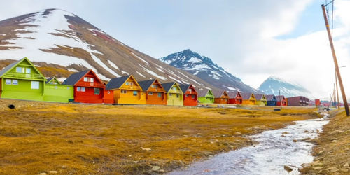 Houses by snowcapped mountains against sky
