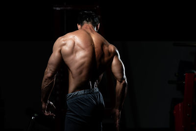 Shirtless man exercising in gym