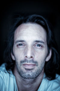 Close-up portrait of young man against black background