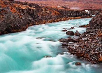 Scenic view of rock formation in water against sky