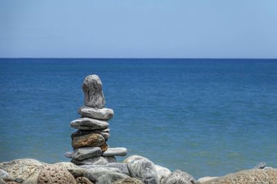 Close-up of rock on sea against clear sky