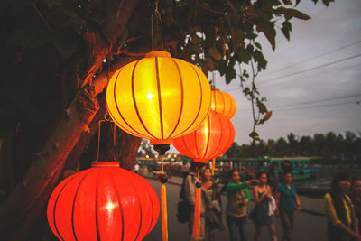 Close-up of illuminated lantern against orange sky