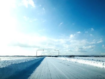 Road by highway against sky during winter