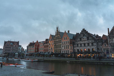 Buildings in city against cloudy sky