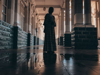 Rear view of silhouette woman standing on floor in building