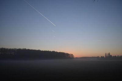 Scenic view of lake against clear sky at sunset