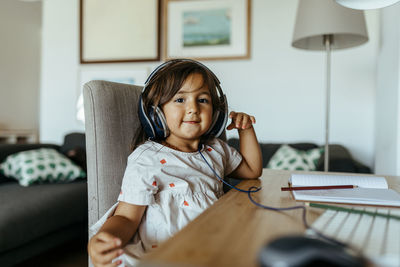 Cute girl wearing headphones at desk