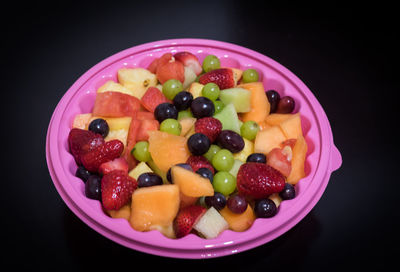 Close-up of fruits in bowl against black background