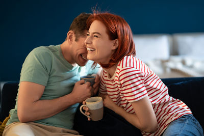 Well rested couple talking laughing and joking sitting on home sofa. happy relationship in family.