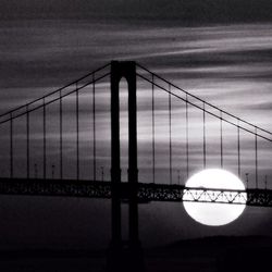 Bridge over river against cloudy sky