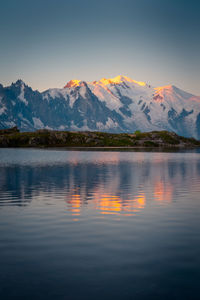 Scenic view of lake by mountains against sky