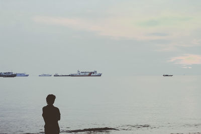 Rear view of man on beach against sky