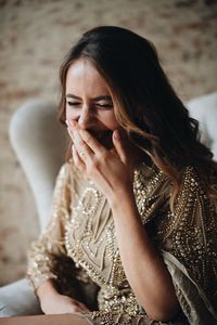 Close-up of happy young woman sitting at home