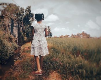 Rear view of woman standing on field